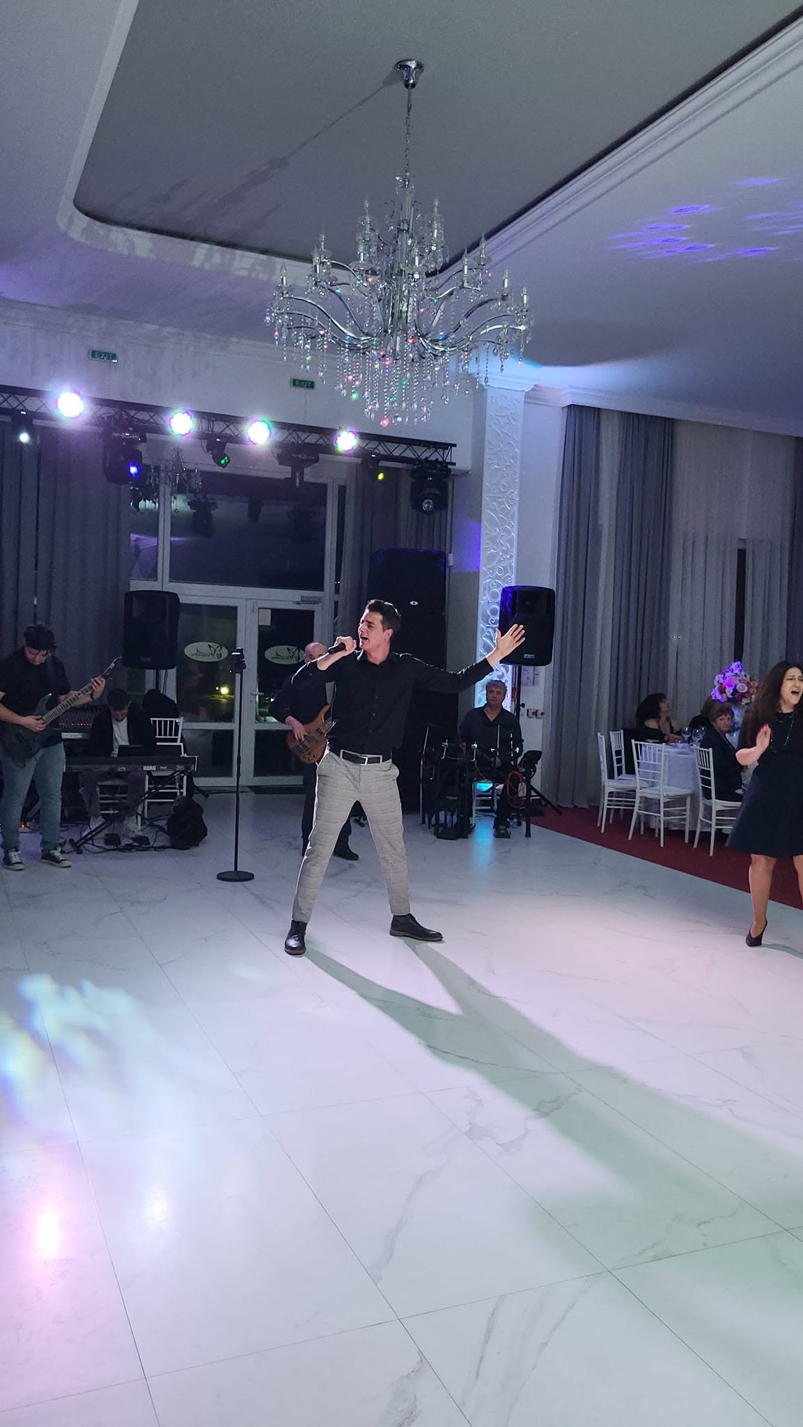 SEE cântând într-o sală de evenimente iluminată